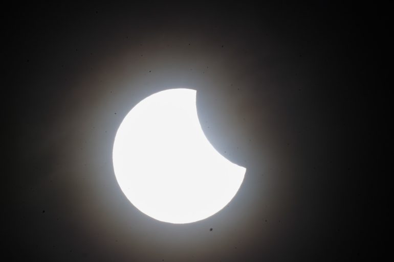 Skygazers catch glimpse of partial solar eclipse